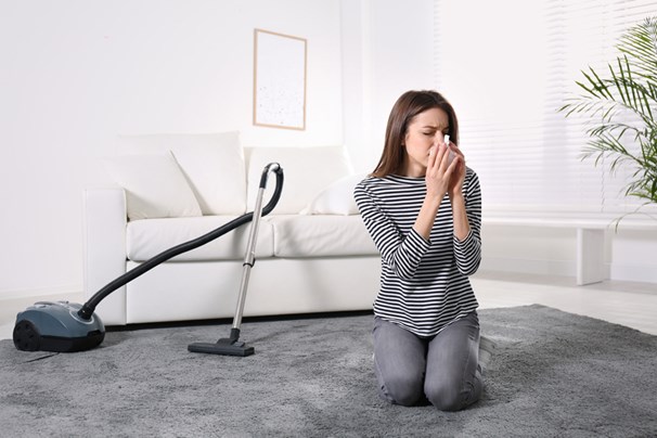 women vacuuming and suffering allergies