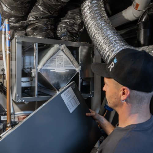Technicien en nettoyage de conduit de ventilation inspectant un système de ventilation central - Royal Nettoyage